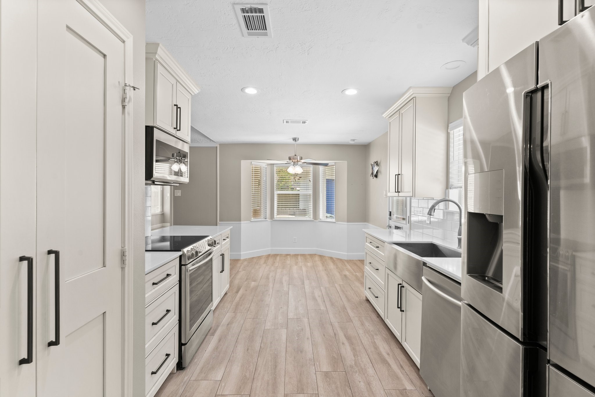 27234 Wells Lane Conroe, TX 77385 - Photo 3 of 15 a large kitchen with stainless steel appliances granite countertop a lot of counter space and wooden floors