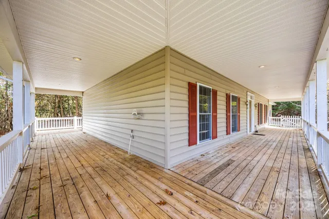a view of a house with a large window and wooden fence