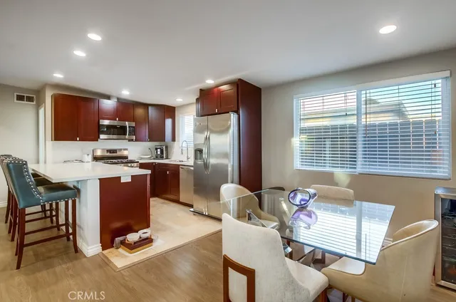 a kitchen with a refrigerator a stove a sink dishwasher with a dining table and chair