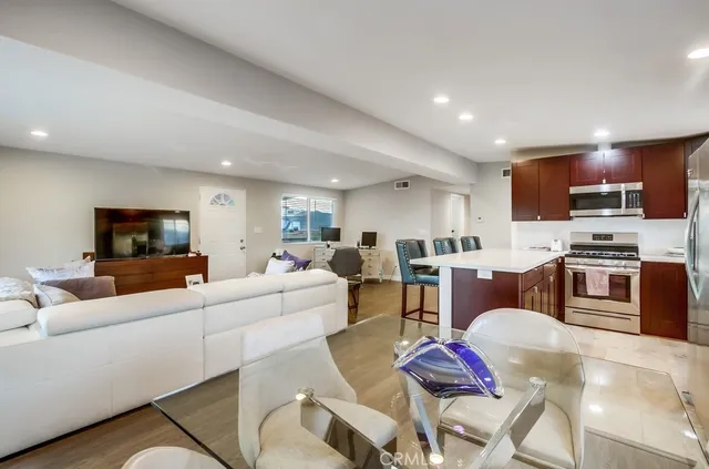 a living room with furniture kitchen view and a window