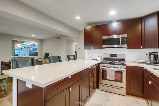 a kitchen with a stove a sink a microwave and cabinets