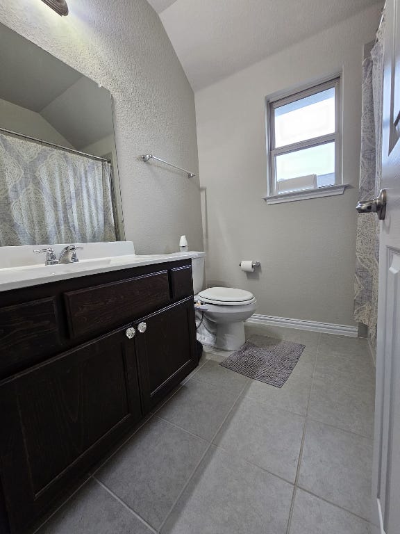 20721 Dustin Lane Pflugerville, TX 78660 - Photo 13 of 27 Full bathroom with curtained shower, vanity, a textured wall, and light tile patterned floors