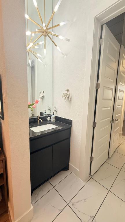 20721 Dustin Lane Pflugerville, TX 78660 - Photo 14 of 27 Half bathroom featuring a textured wall, vanity, and light marble finish floors