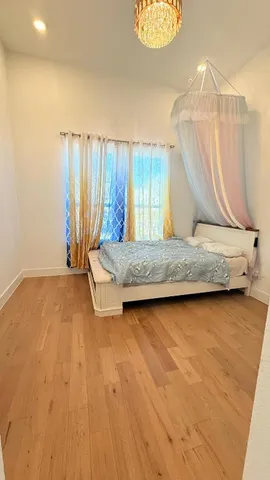 a living room with a bed furniture and a wooden floor