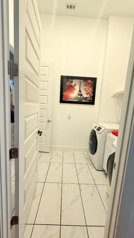 20721 Dustin Lane Pflugerville, TX 78660 - Photo 21 of 27 Laundry room with light marble finish floors and washing machine and dryer