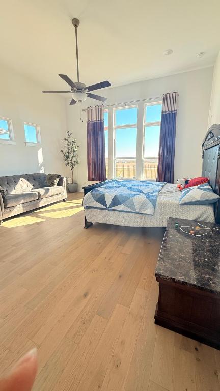 20721 Dustin Lane Pflugerville, TX 78660 - Photo 5 of 27 Bedroom with multiple windows, light wood-type flooring, and access to exterior