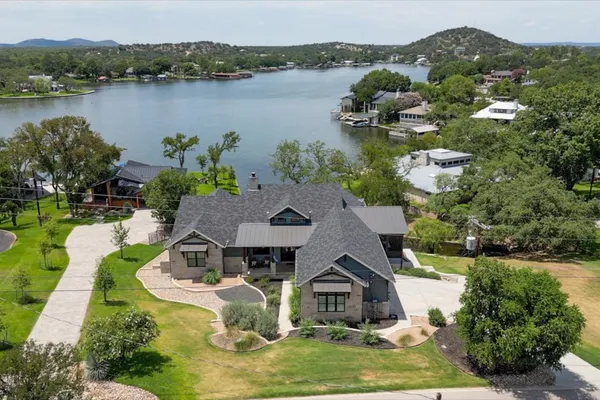 an aerial view of a house with swimming pool and lake view