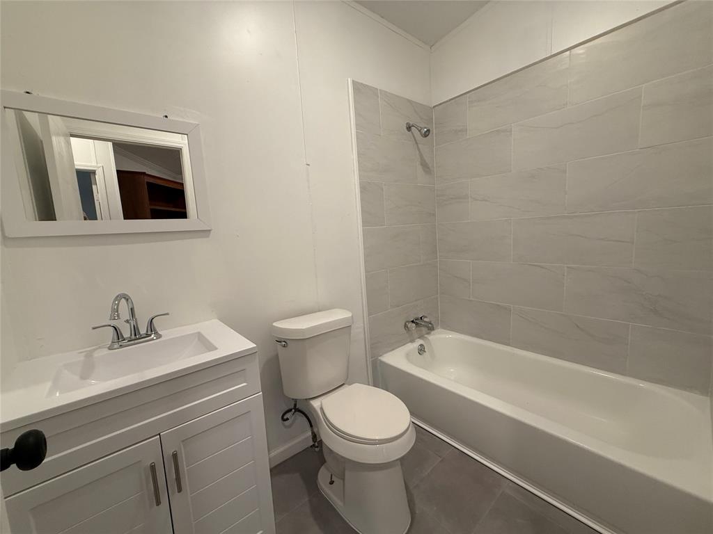 2002 County Road 906 Princeton, TX 75407 - Photo 17 of 31 a bathroom with a toilet a sink a mirror and bathtub