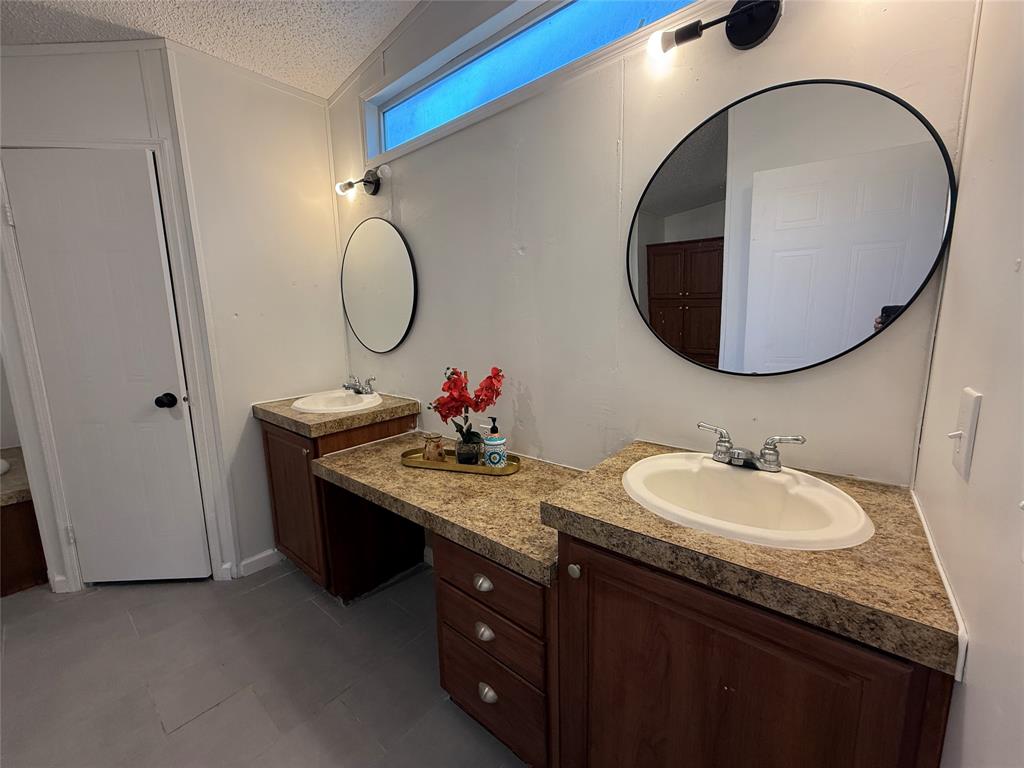 2002 County Road 906 Princeton, TX 75407 - Photo 19 of 31 a bathroom with a granite countertop double vanity sink and a mirror