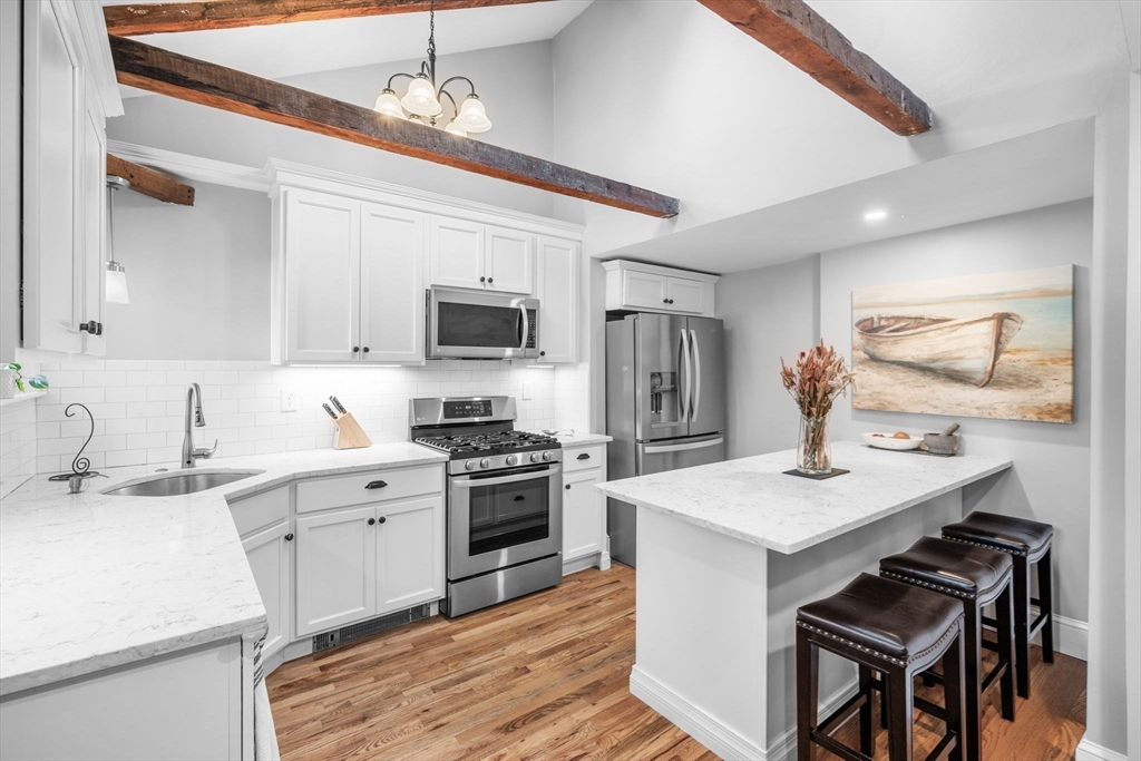 20 Summer Street, Unit 20 Ipswich, MA 01938 - Photo 15 of 42 a kitchen with stainless steel appliances kitchen island granite countertop a sink stove and refrigerator