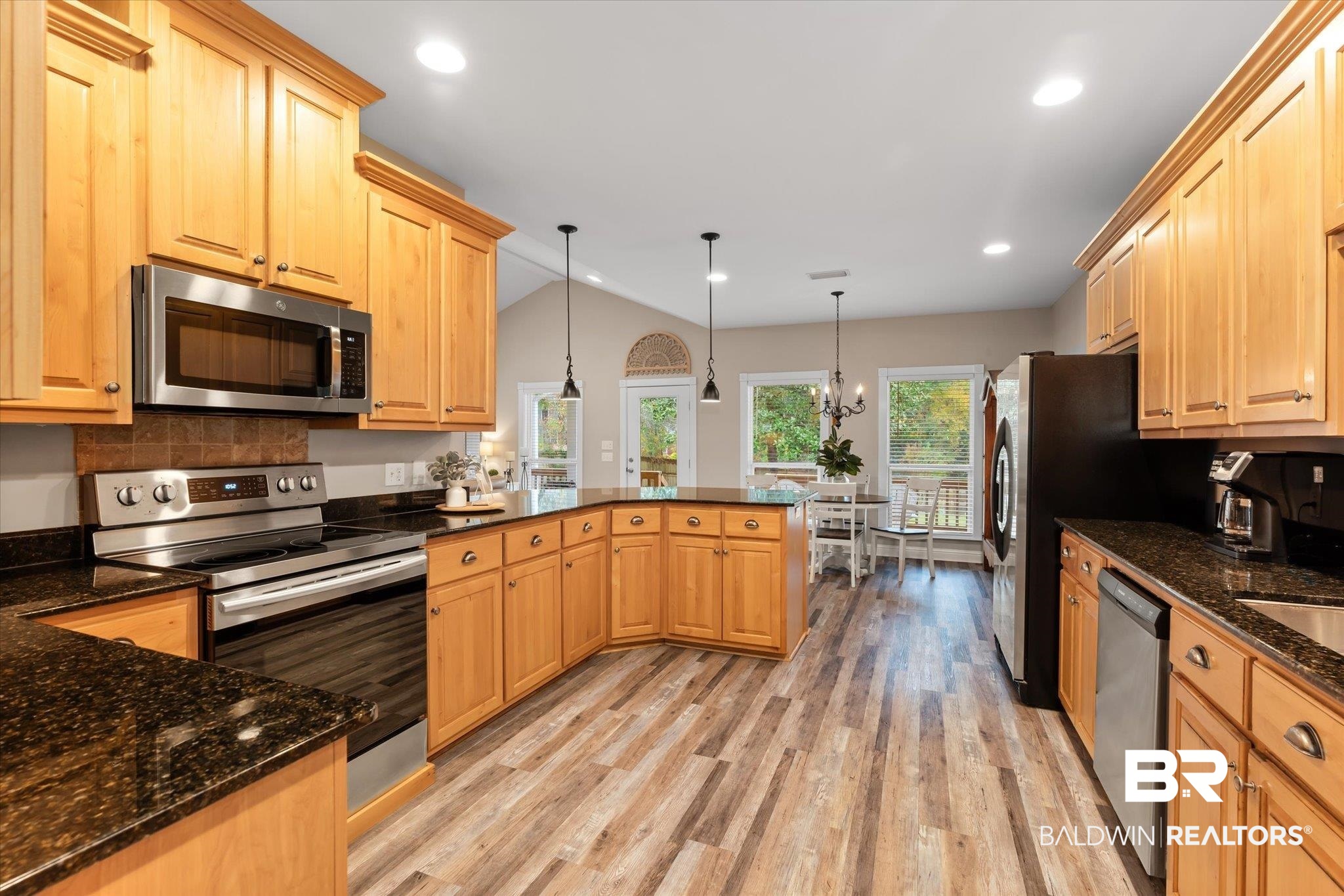 27994 Oakachoy Loop Daphne, AL 36526 - Photo 6 of 41 Kitchen featuring stainless steel appliances, light brown cabinets, light hardwood / wood-style floors, hanging light fixtures, and lofted ceiling