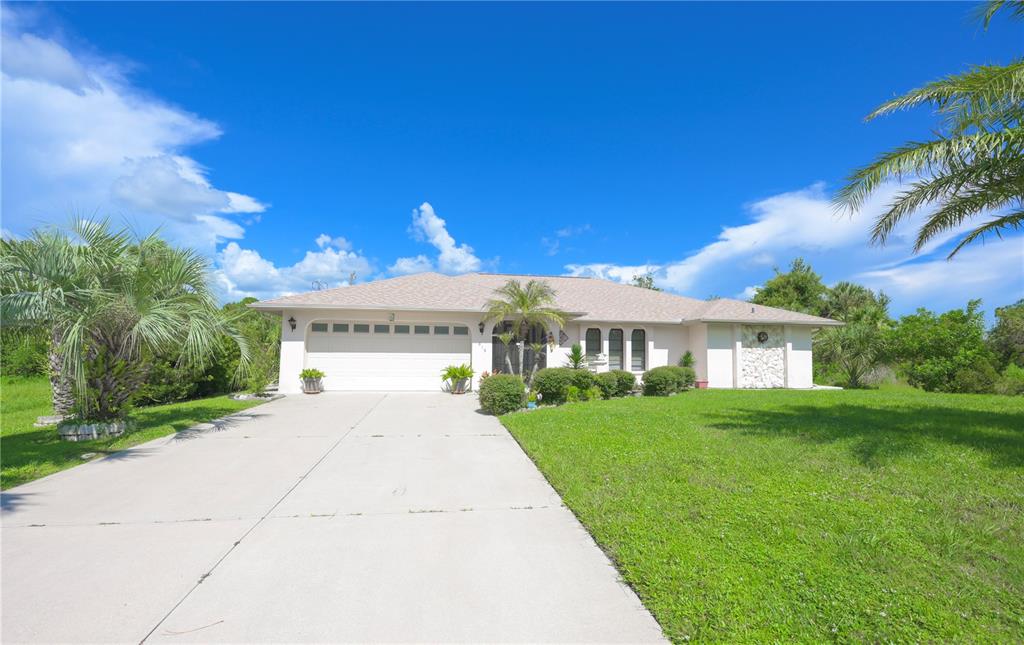 a view of house in front of a big yard with large trees