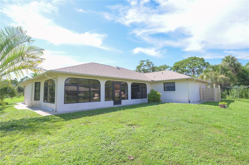 615 Toledo Road North Port, FL 34287 - Photo 16 of 16 a view of a yard in front of a house with large windows