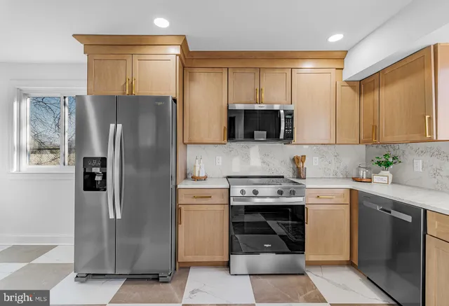 a kitchen with stainless steel appliances granite countertop a refrigerator stove and sink