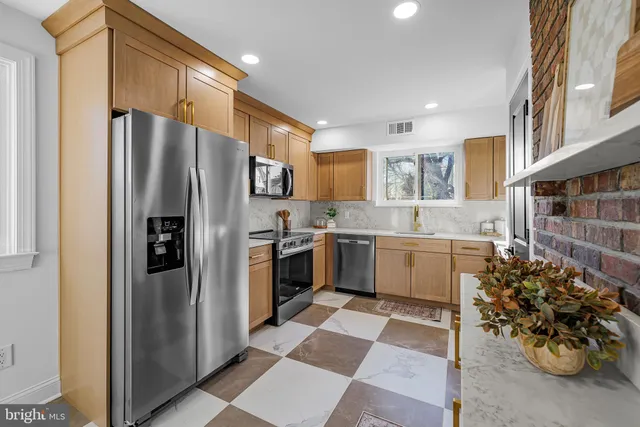 a kitchen with stainless steel appliances a refrigerator sink and cabinets