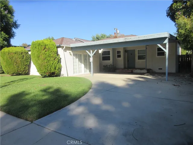 a front view of a house with a yard and potted plants