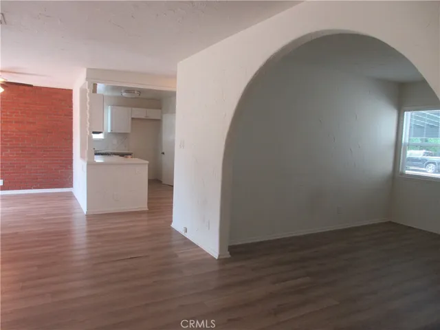 a view of a room with wooden floor and a bathroom