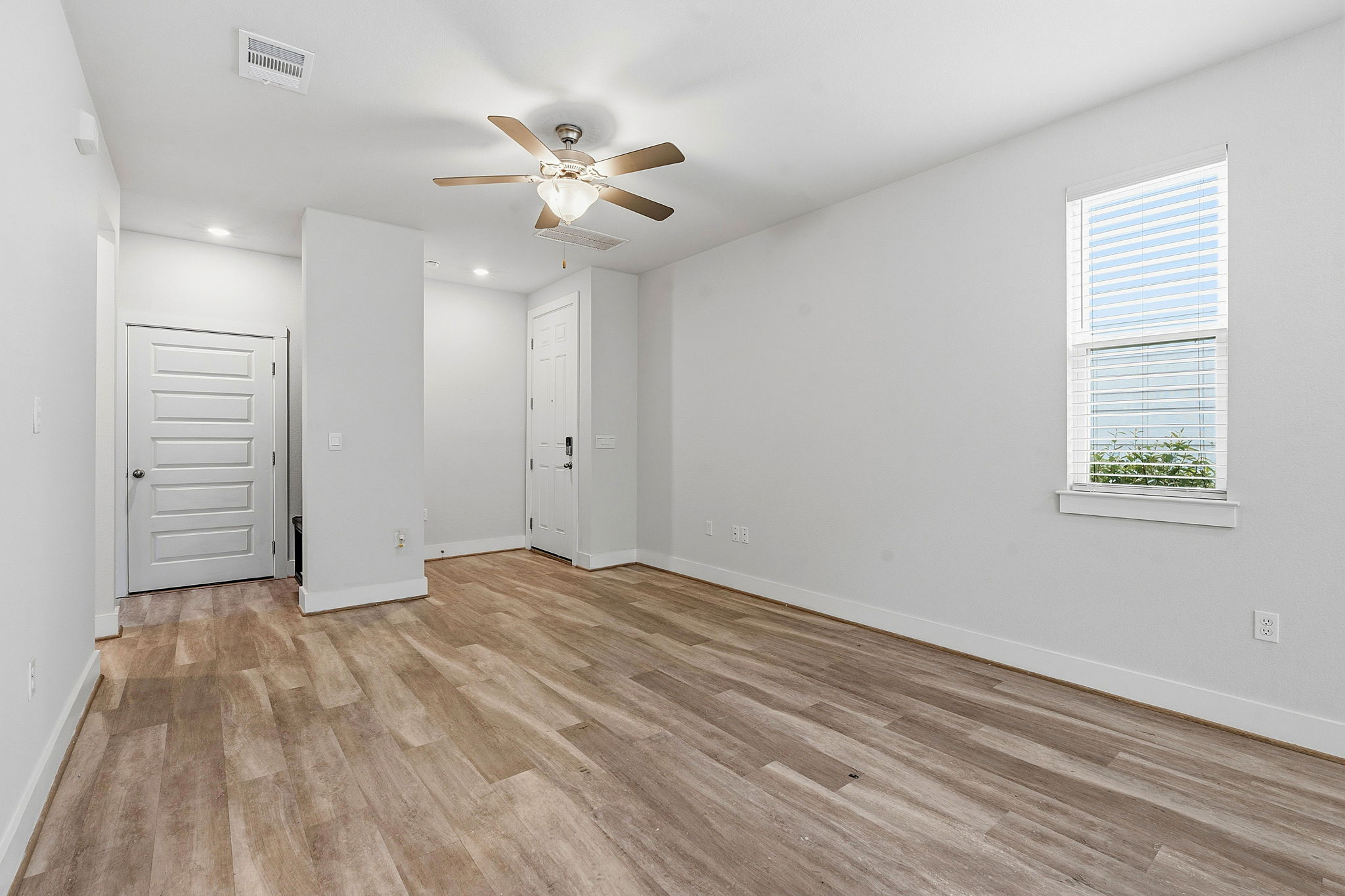 7105 Silver Star Lane, Unit 59 Austin, TX 78744 - Photo 4 of 19 a view of an empty room with wooden floor and a window