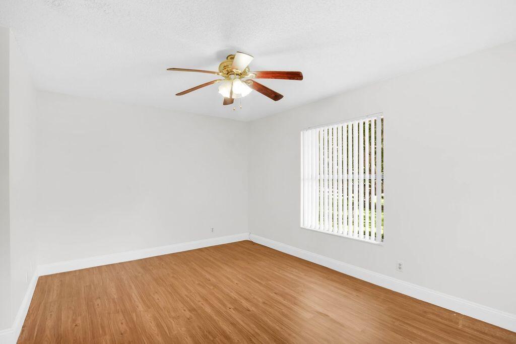 3300 Jaywood Terrace, Unit 2160 Boca Raton, FL 33431 - Photo 16 of 28 an empty room with wooden floor fan and windows