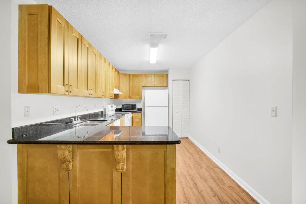3300 Jaywood Terrace, Unit 2160 Boca Raton, FL 33431 - Photo 7 of 28 a kitchen with granite countertop cabinets and stainless steel appliances