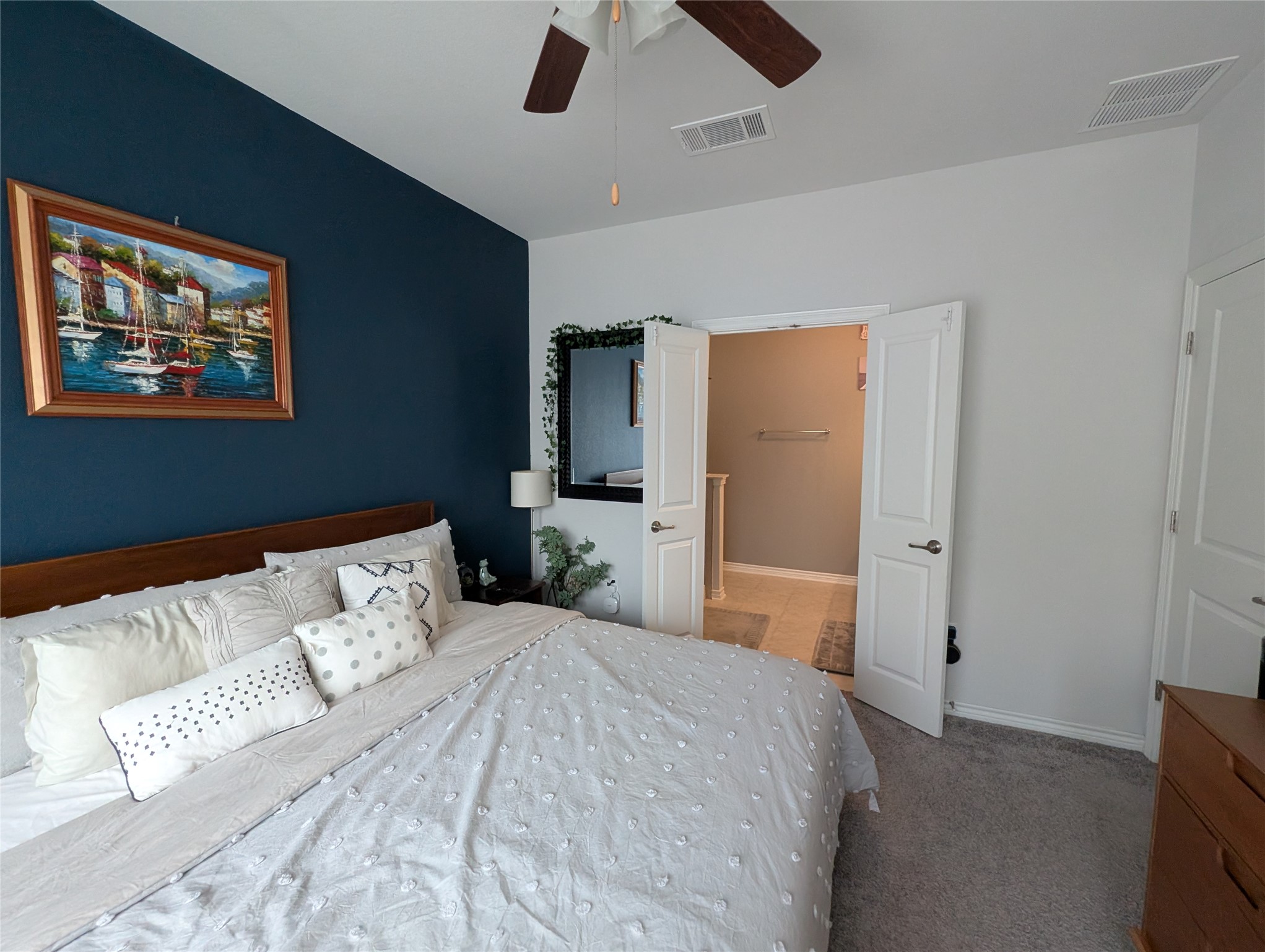 14502 McCoy Loop Austin, TX 78717 - Photo 12 of 26 Bedroom featuring a dark accent wall, ceiling fan, and carpeted flooring