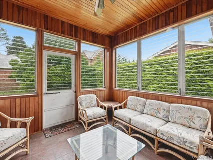 a living room with furniture and floor to ceiling windows