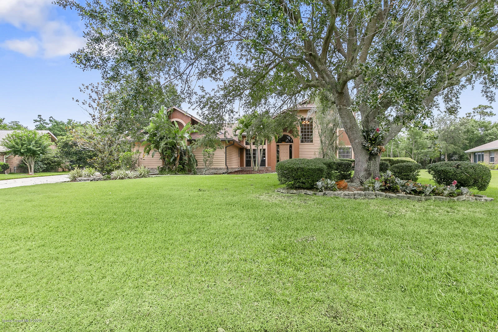 3805 Shady Run Road Melbourne, FL 32934 - Photo 2 of 42 a backyard of a house with plants and large tree