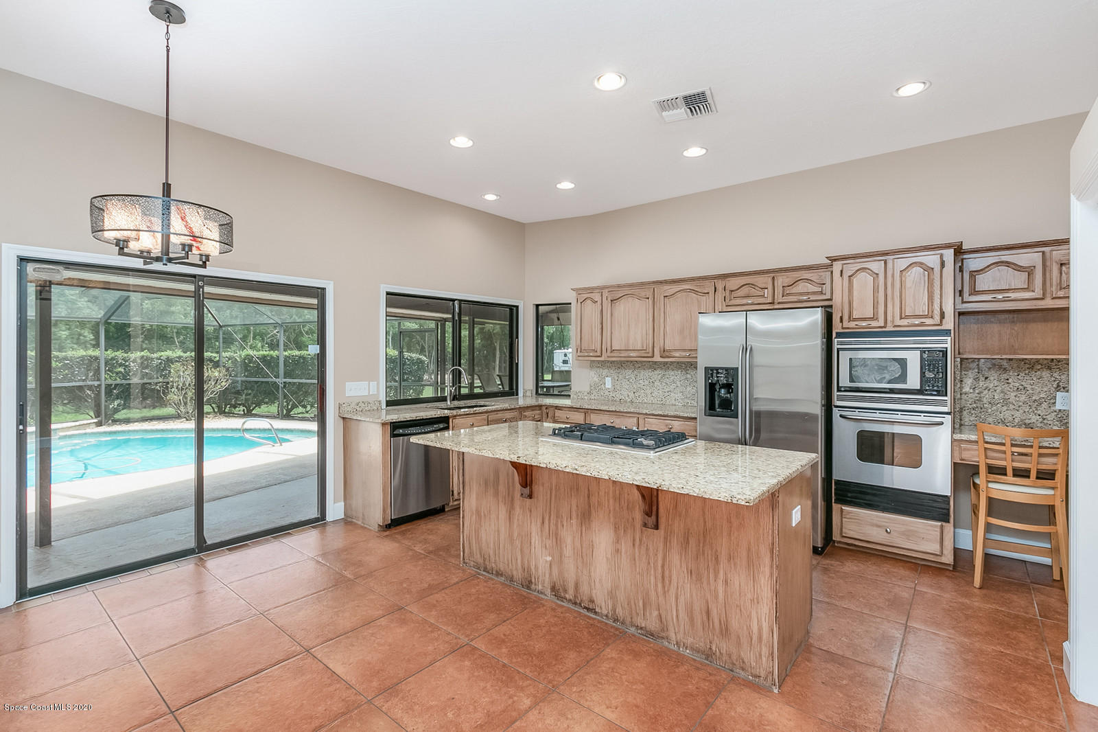 3805 Shady Run Road Melbourne, FL 32934 - Photo 18 of 42 a large kitchen with kitchen island a large counter space a sink appliances and cabinets