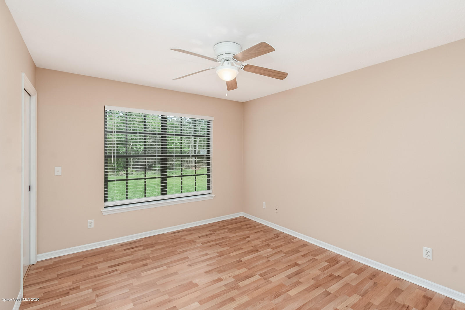 3805 Shady Run Road Melbourne, FL 32934 - Photo 23 of 42 an empty room with wooden floor fan and windows