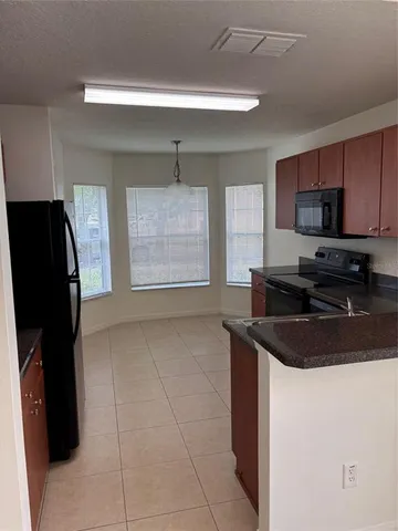 a kitchen with a sink a refrigerator and cabinets