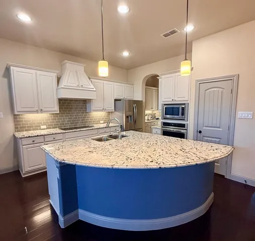a kitchen with kitchen island granite countertop wooden cabinets and a granite counter tops