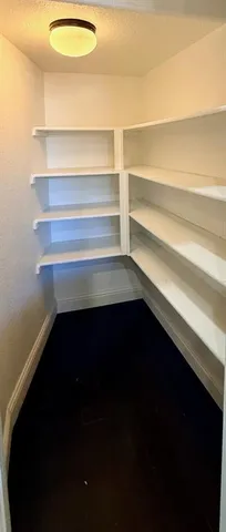 a living room with kitchen view and wooden floors