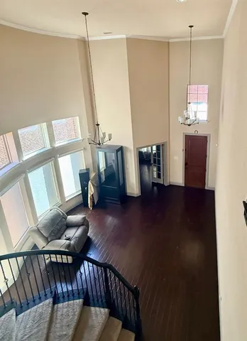 a view of an empty room with wooden floor fireplace and a window