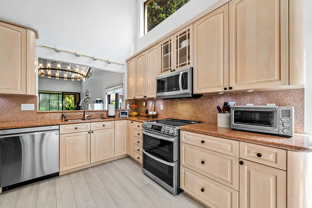 a kitchen with stainless steel appliances a stove a sink and a refrigerator