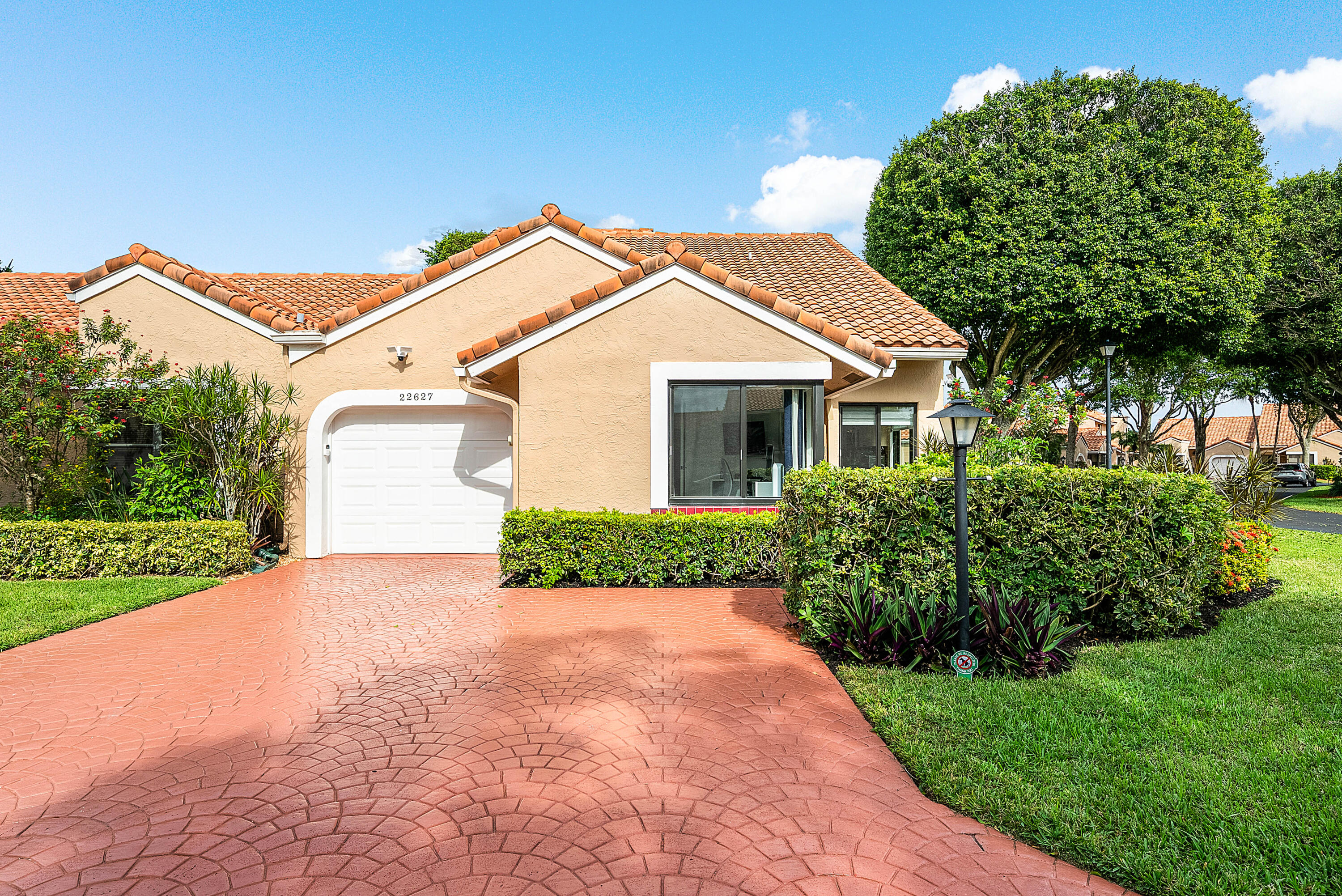 22627 Meridiana Drive Boca Raton, FL 33433 - Photo 2 of 58 a front view of a house with a yard and garage