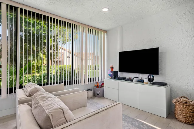 a bedroom with a bed and a flat tv screen on the dresser