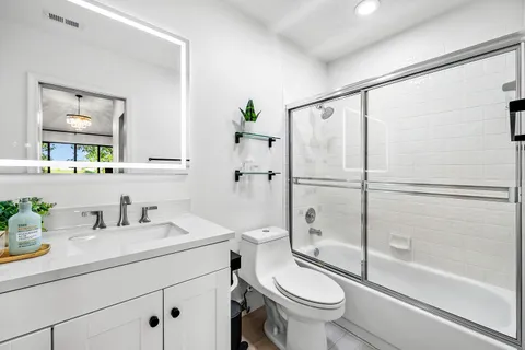 a bathroom with a sink a toilet and shower