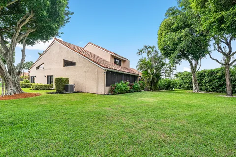 an aerial view of a house with a yard and a large tree