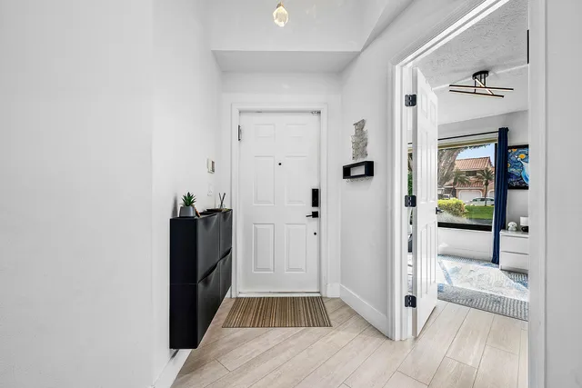 a view of a hallway with wooden floor and staircase