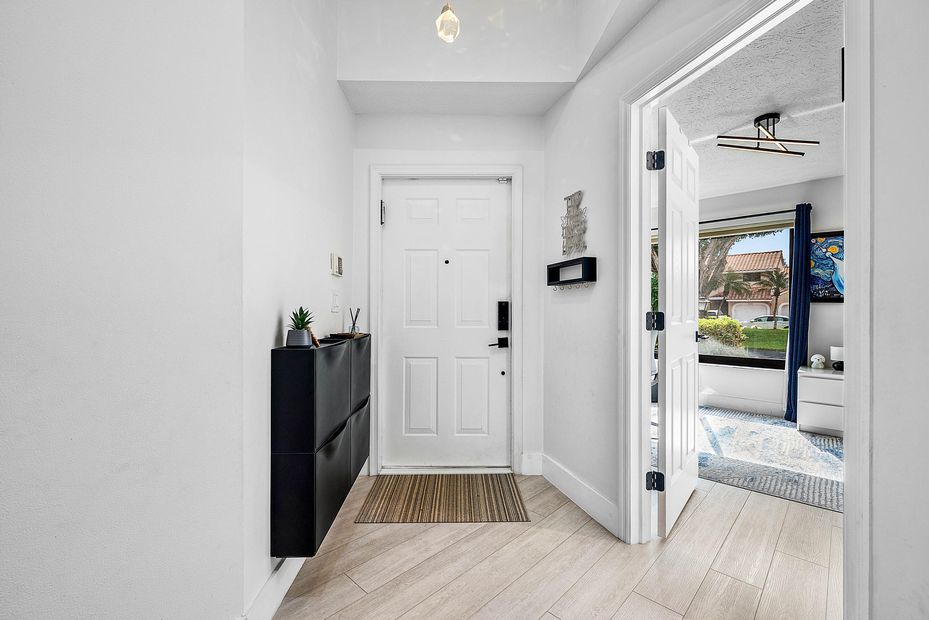 22627 Meridiana Drive Boca Raton, FL 33433 - Photo 5 of 58 a view of a hallway with wooden floor and a bathroom