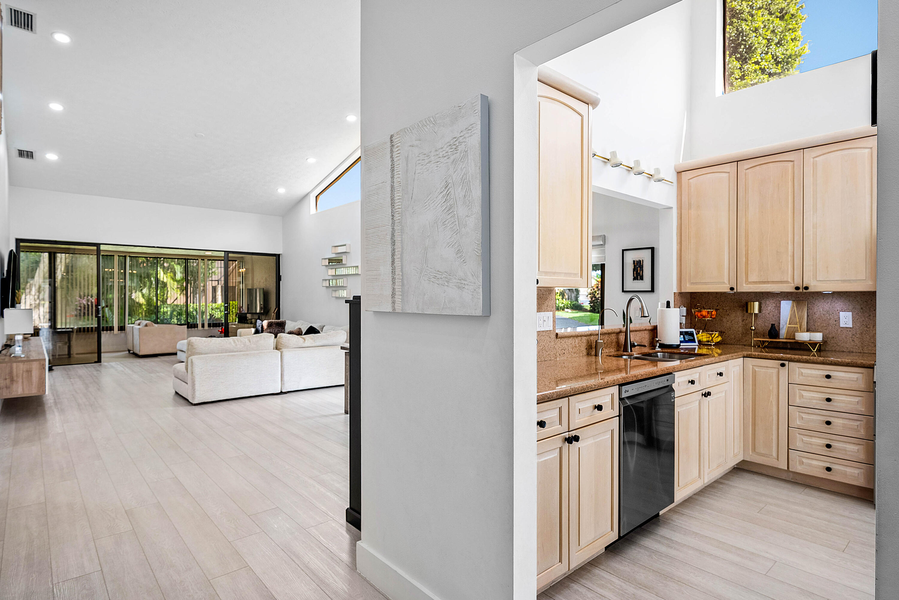 22627 Meridiana Drive Boca Raton, FL 33433 - Photo 7 of 58 a large white kitchen with stainless steel appliances granite countertop a stove a sink dishwasher and a refrigerator with wooden floor
