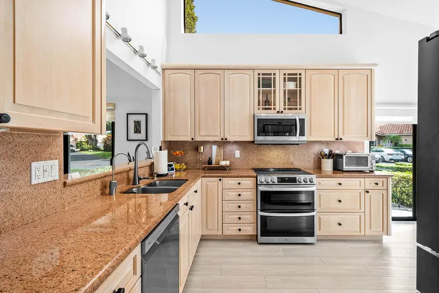 a kitchen with stainless steel appliances a stove a sink and a microwave