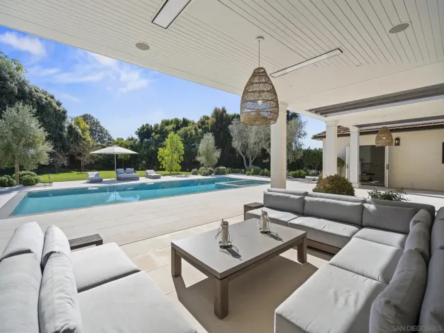 a view of a patio with couches table and chairs and potted plants