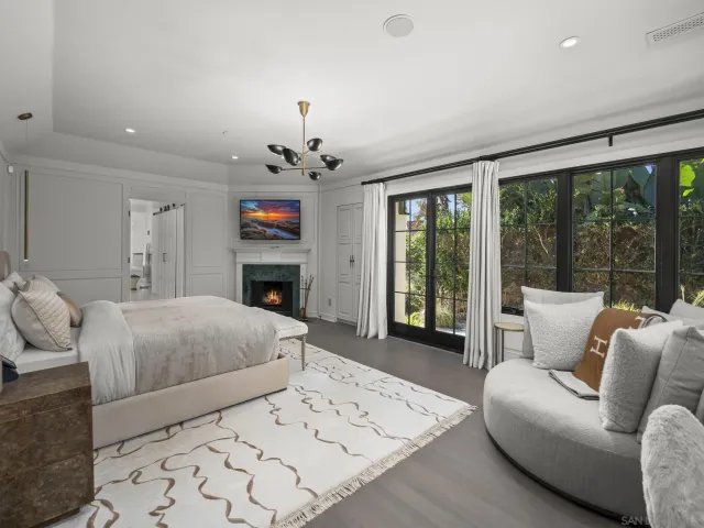 a spacious bedroom with a bed and a chandelier