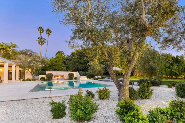 a dining room with wooden floor a chandelier a wooden table and chairs