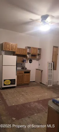 a living room with stainless steel appliances kitchen island granite countertop a sink and cabinets