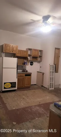 a living room with stainless steel appliances kitchen island granite countertop a sink and cabinets