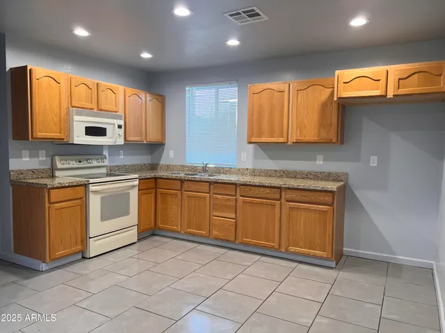 a kitchen with stainless steel appliances granite countertop a stove sink and cabinets