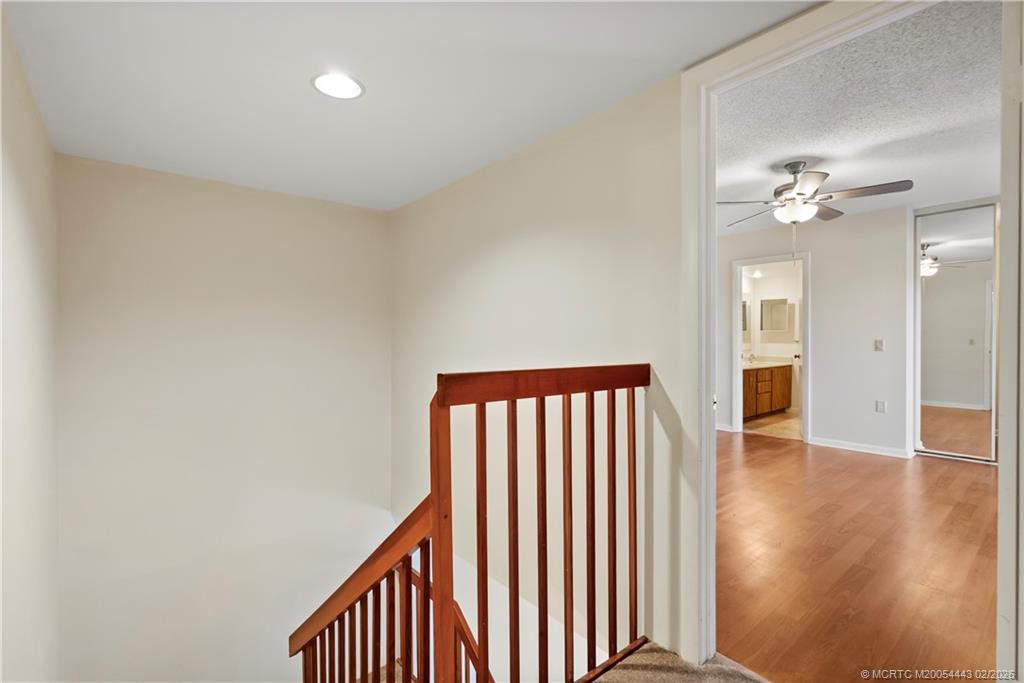 2930 Southwest Sunset Trace Circle Palm City, FL 34990 - Photo 12 of 31 a view of a hallway with wooden floor and chandelier