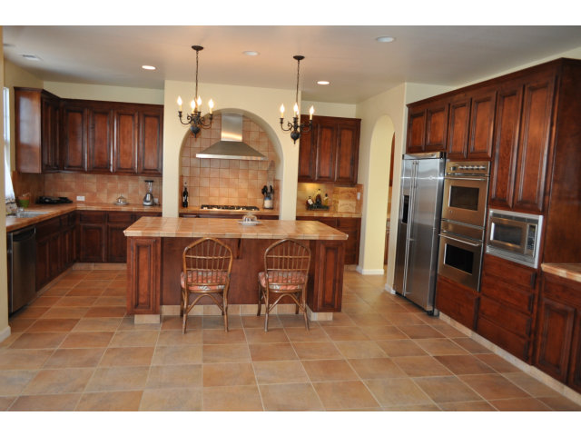 6560 Eagle Ridge Court Gilroy, CA 95020 - Photo 7 of 18 a kitchen with stainless steel appliances kitchen island granite countertop a table chairs and a refrigerator